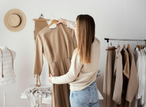 girl with a brown dress in front of a clothing rack_>w.i.c. room