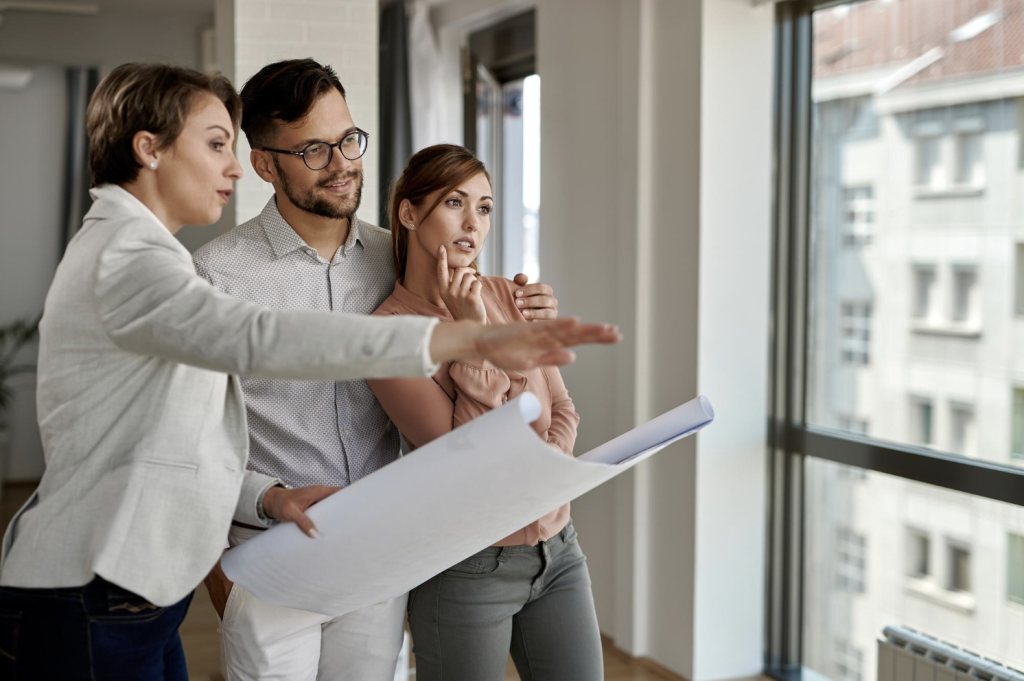 realtor showing couple an apartment and pointing out the window_apartment insider